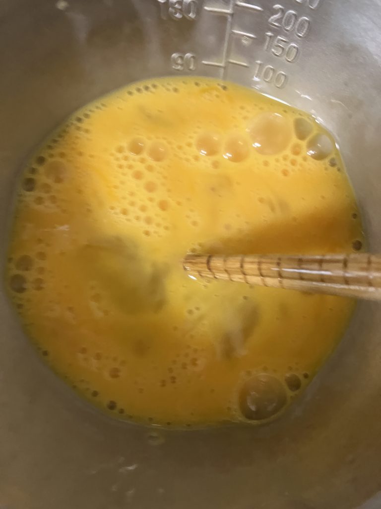  Beaten egg being poured into the oyakodon mixture