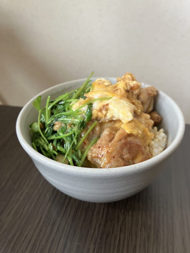Close-up of finished oyakodon topped with green herbs